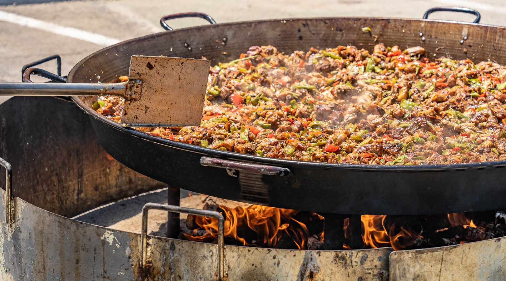 Paella monumental de Tasca del Puerto cociéndose a fuego de leña