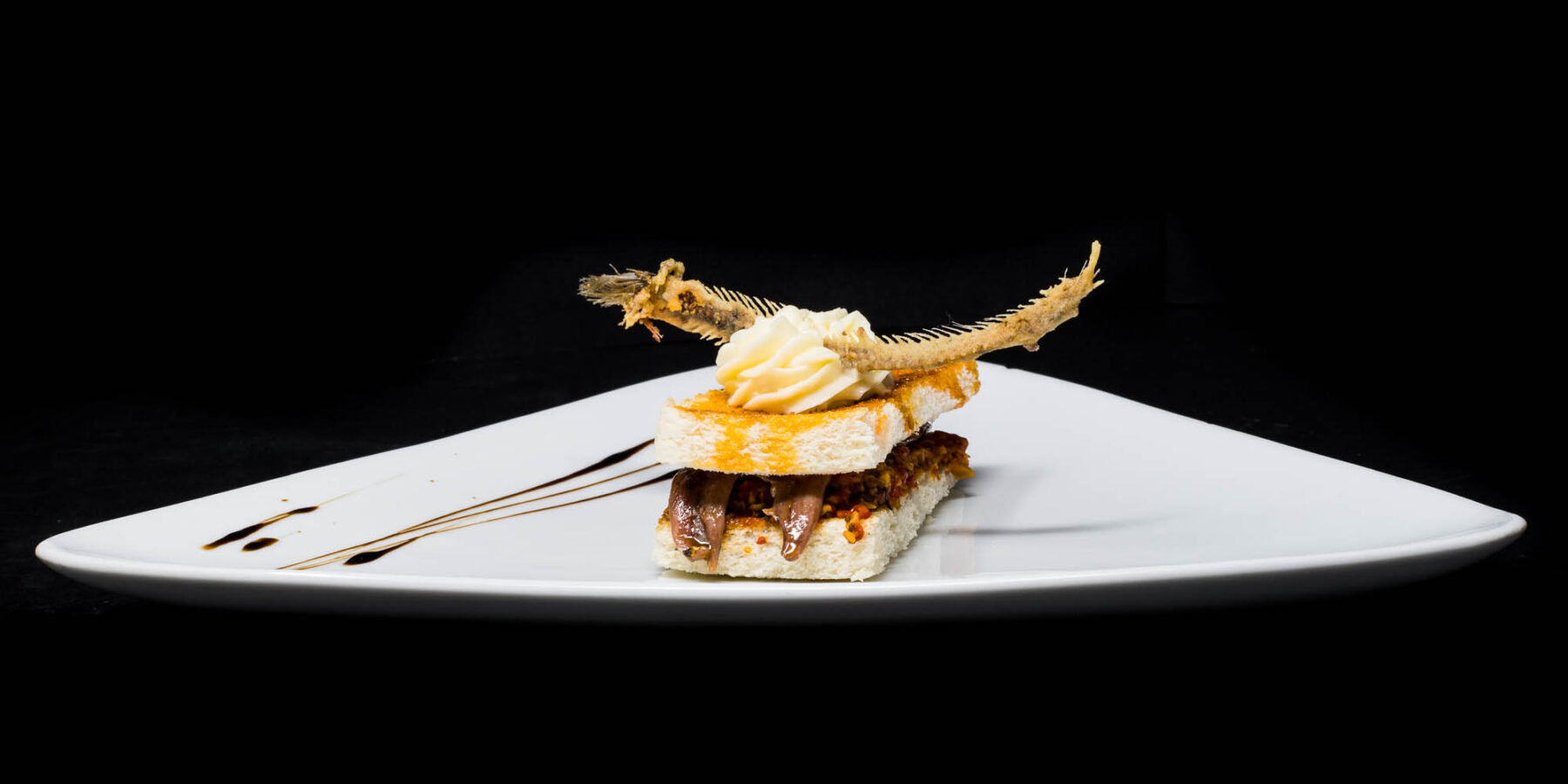 Pescado de lonja emplatado sobre fondo negro